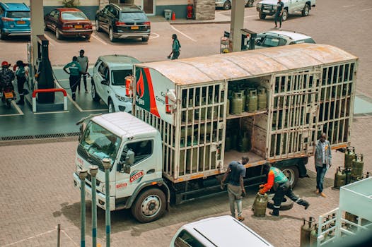 An LPG gas truck making a delivery at a busy urban station.