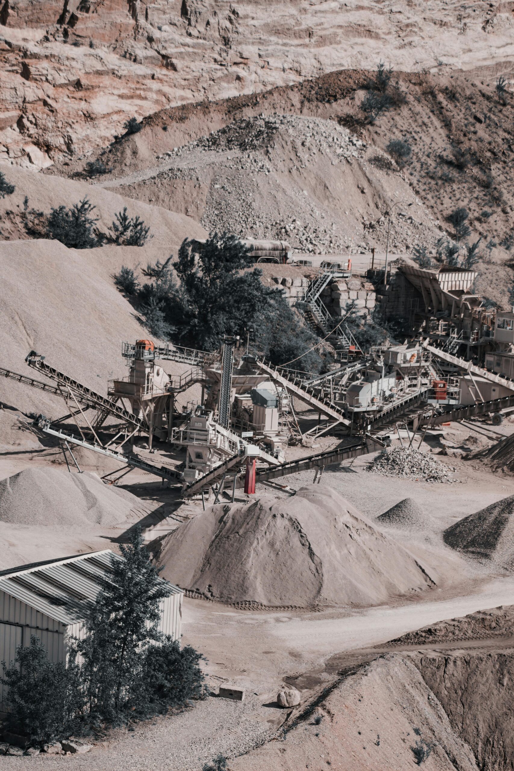 Aerial view of a large quarry with industrial machinery and equipment in operation.