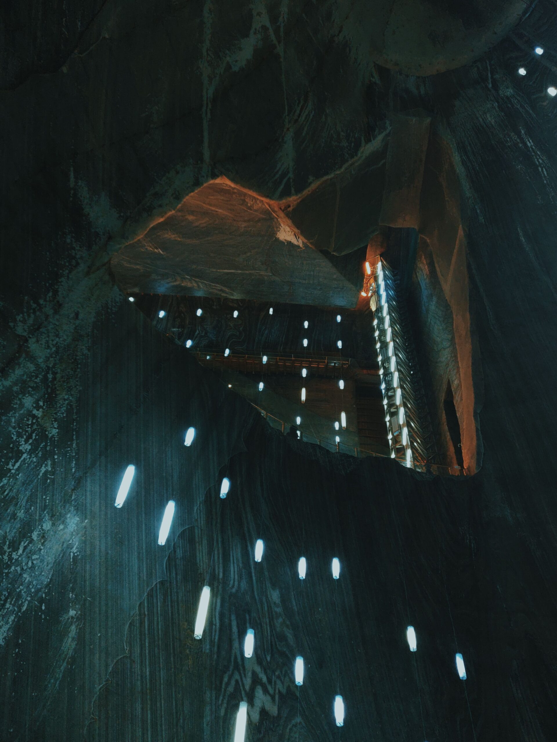 Explore the dramatic light play inside Turda Salt Mine, showcasing amazing geological formations.